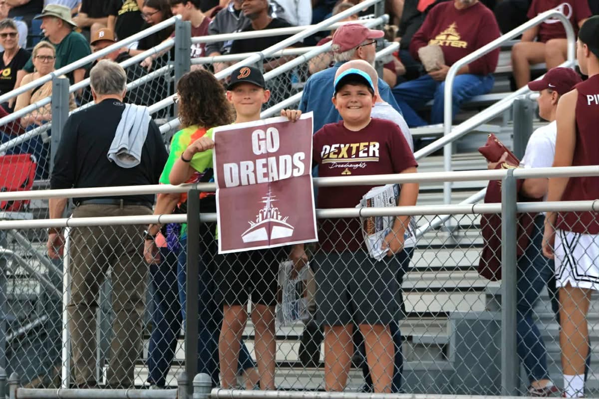 A young Sun Times News reader holding a Spirit Page at a football game